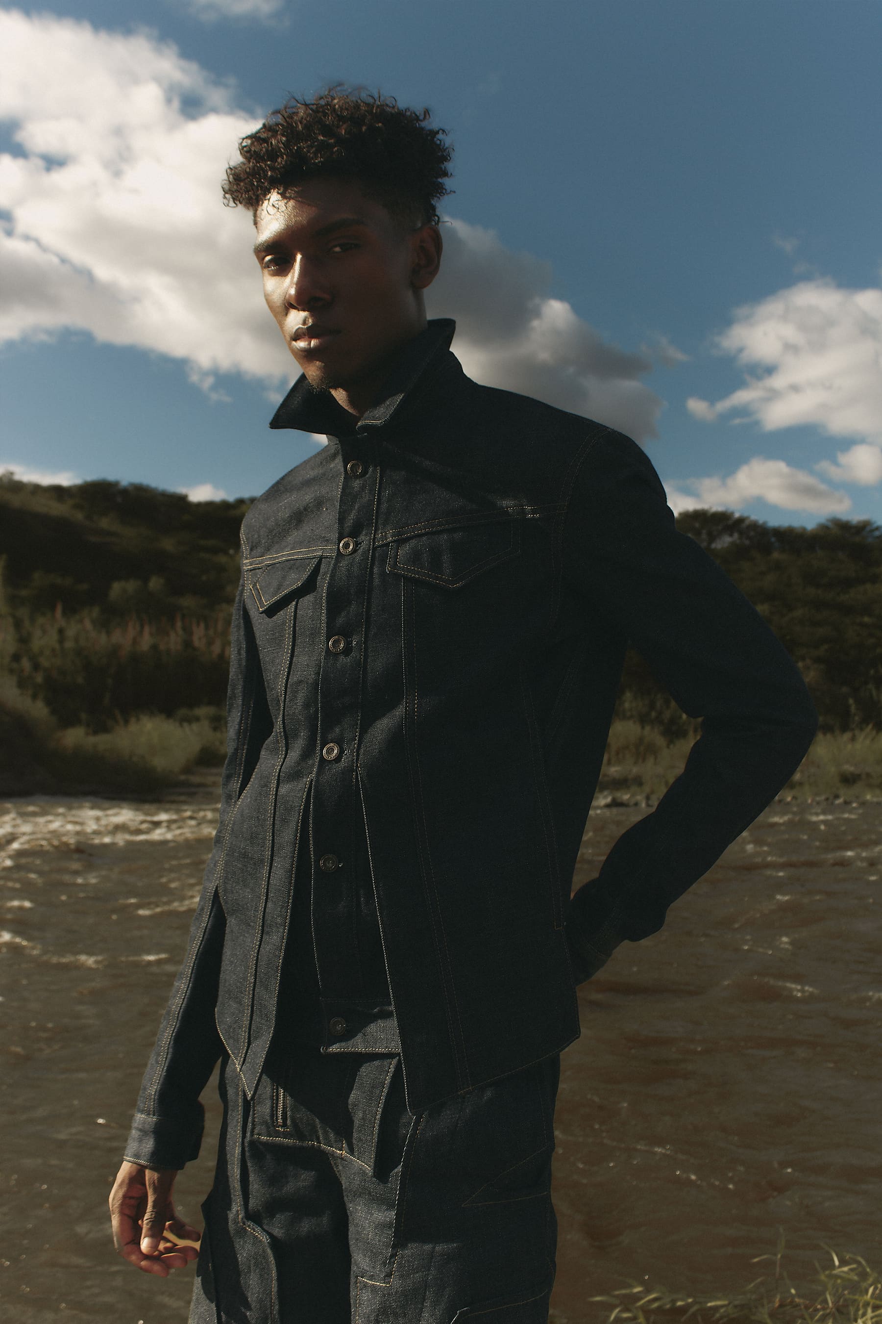 Editorial Coangue: modelo junto al río con conjunto sastre en denim oscuro.