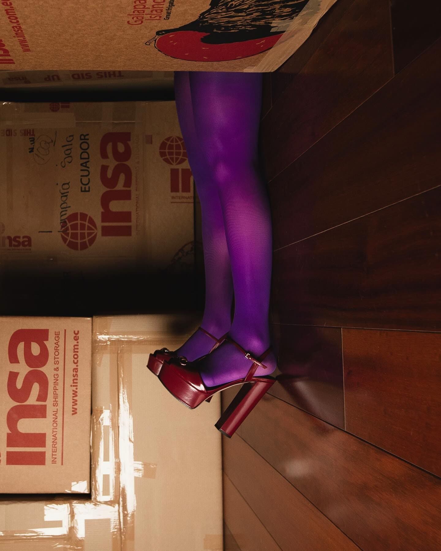 Editorial InStyle Grecia: modelo entre cajas de mudanza, vista cenital.